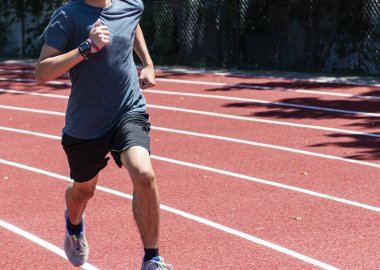 Kırmızı yolda saat yönünde koşan genç çocuk