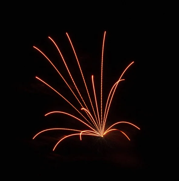 В небе взрываются оранжевые фейерверки — стоковое фото
