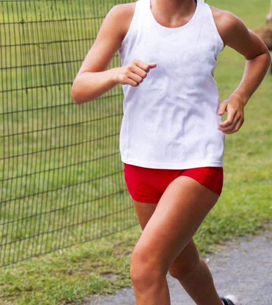 Female runner in white and red uniform racing Royalty Free Stock Photos
