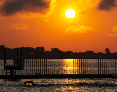 Güneş yükselen ve h turuncu güneşin feflection ile havuzda kaynatın