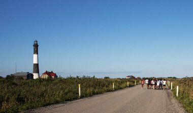 Fire Island Lighthouse with group of girls running on dirt road clipart