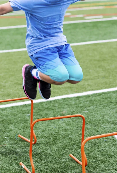 Adolescente saltando sobre laranja mini obstáculo no acampamento de verão — Fotografia de Stock
