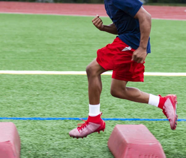 Fotbalista při letním tréninku přejede přes červené bariéry — Stock fotografie