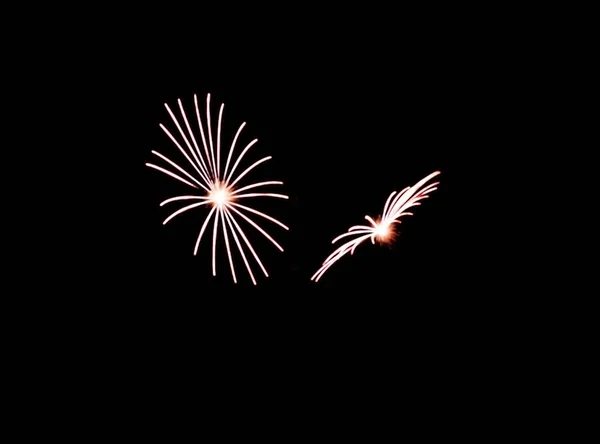 Zwei kleine weiße Feuerwerkskörper explodieren während der Show am Himmel — Stockfoto