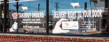 Babylon, New York, ABD - 13 Mayıs 2020: Coronavirus COVID-19 salgını nedeniyle Babil Köyü 'ndeki bir restoranın vitrininde paket servisi için hazır durumda..
