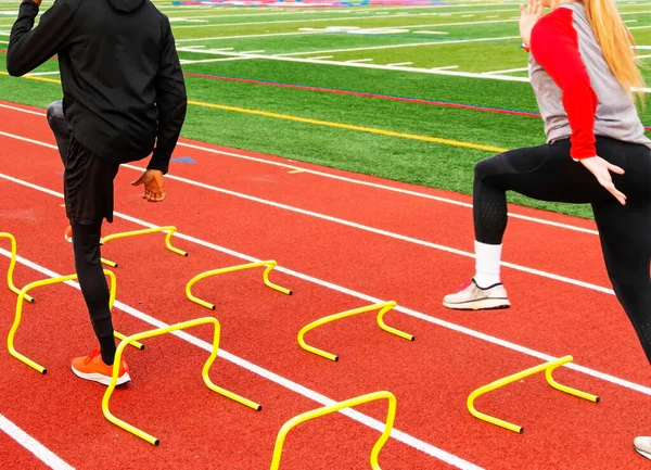 Vista Trasera Atletas Masculinos Femeninos Corriendo Sobre Mini Obstáculos Amarillos — Foto de Stock