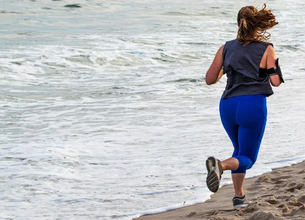 Visão Traseira Uma Mulher Correndo Praia Pela Água Areia — Fotografia de Stock