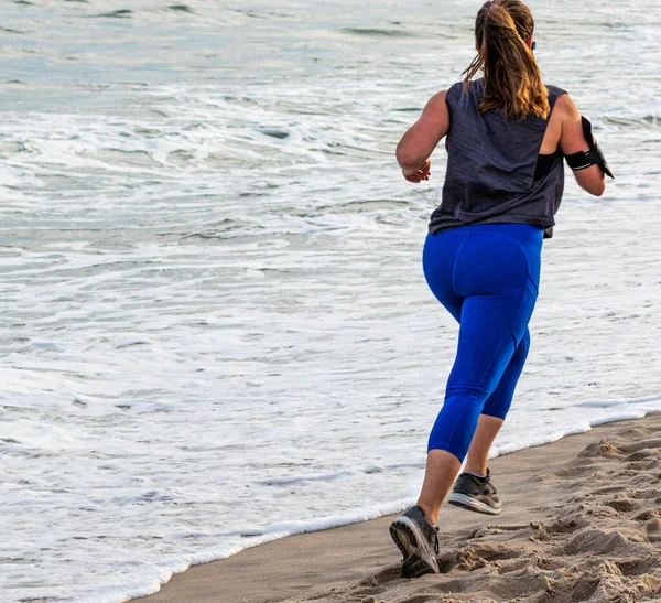 Uma Fêmea Spandex Azul Está Correndo Praia Perto Oceano Fire — Fotografia de Stock