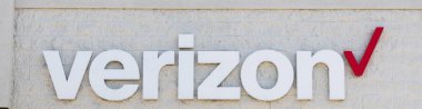 Bay Shore, New York, ABD - 25 Nisan 2020: Beyaz tuğla bina üzerinde kırmızı onay işareti olan beyaz bir verizon tabelanın manzarası.