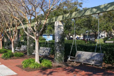 Beaufort, Güney Carolina, ABD - 19 Şubat 2024: Henry Chambers Park 'ta güzel bir parkta dinlenebilmek için salıncakta sallanan birkaç ahşap bank.