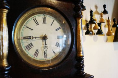 Güzel oklar ve sıradışı satranç taşları içinde belgili tanımlık geçmiş ile eski ahşap saat