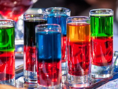 Farklı yoğunlukta ve farklı renklerde içecekler cam kaplara dökülür