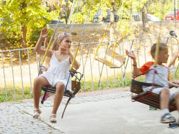 Vinnitsa, Ucrania. 08. 24. 2019. Chica y niño montar un carrusel en una atracción — Foto de Stock