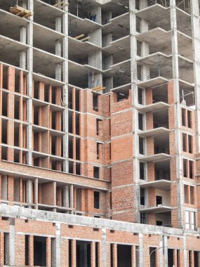 Yeni bir bitmemiş binanın sütunları ile Tuğla duvar