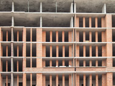 Yeni bir bitmemiş binanın sütunları ile Tuğla duvar