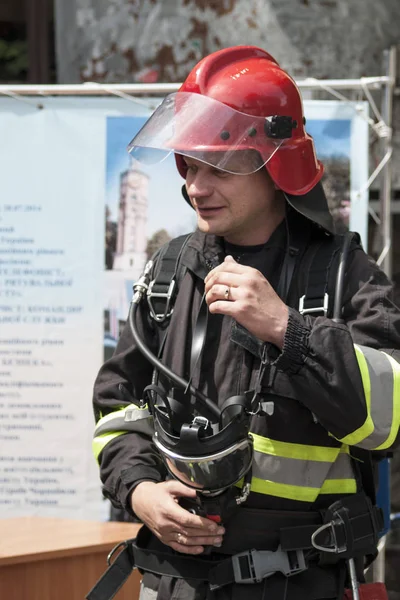 Winnica, Ukraina-22 maja 2018: strażak przygotowuje się do ukończenia niebezpiecznej misji w płonącym domu — Zdjęcie stockowe
