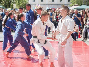 Vinnitsa, Ukrayna - 22 Mayıs 2018: Kimonolu erkek ve kızlar sokaktaki herkesi nefsi müdafaa priyom olarak gösteriyor