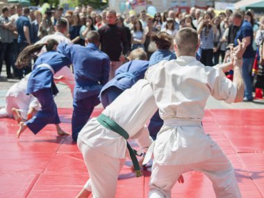 Vinnitsa, Ukrayna - 22 Mayıs 2018: Kimonolu erkek ve kızlar sokaktaki herkesi nefsi müdafaa priyom olarak gösteriyor