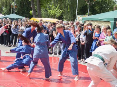 Vinnitsa, Ukrayna - 22 Mayıs 2018: Kimonolu erkek ve kızlar sokaktaki herkesi nefsi müdafaa priyom olarak gösteriyor