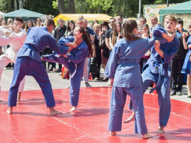 Vinnitsa, Ukrayna - 22 Mayıs 2018: Kimonolu erkek ve kızlar sokaktaki herkesi nefsi müdafaa priyom olarak gösteriyor