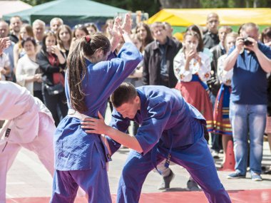 Vinnitsa, Ukrayna - 22 Mayıs 2018: Kimonolu erkek ve kızlar sokaktaki herkesi nefsi müdafaa priyom olarak gösteriyor