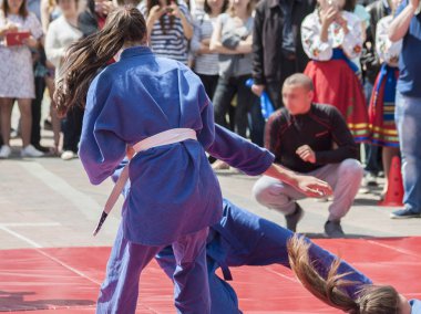 Vinnitsa, Ukrayna - 22 Mayıs 2018: Kimonolu erkek ve kızlar sokaktaki herkesi nefsi müdafaa priyom olarak gösteriyor