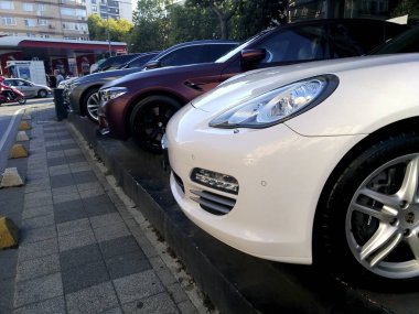 İstanbul, Türkiye - 9 Ağustos 2019 : Beyaz bir Porsche, bir Bmw M5 ve satılık sokakta yandan ve ön görünümden gri bir Bmw. Deniz Bank Atm ve Po Akaryakıt İstasyonu da görülebilir.