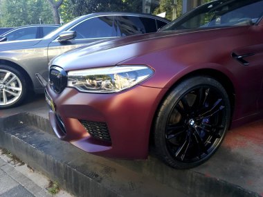 İstanbul, Türkiye - 9 Ağustos 2019 : Açık havada yan ve ön görünümden mat mor renkli ve siyah çerçeveli özel Bmw M5.