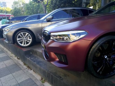 İstanbul, Türkiye - 9 Ağustos 2019 : Yan ve ön görünümden mat mor renkli ve siyah çerçeveli özel Bmw M5 ve açık havada gri bir Bmw.
