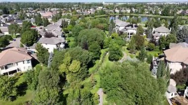 Arbor Creek evleri, parklar ve banliyö planlarını vurgulayan pürüzsüz 4K hava aracı klibi