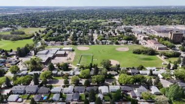 Saskatoon 'daki Eastview' in 4K hava manzarasında yerleşim caddeleri, parklar ve okullar yer alıyor..