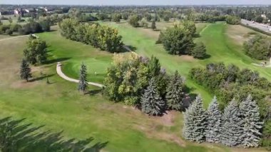 Saskatoon 'daki Wildwood' un 4K hava manzarasında yerleşim evleri, okullar, parklar ve Wildwood Golf Sahası yer alıyor..
