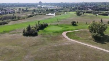 Saskatoon 'daki Wildwood' un 4K hava manzarasında yerleşim evleri, okullar, parklar ve Wildwood Golf Sahası yer alıyor..