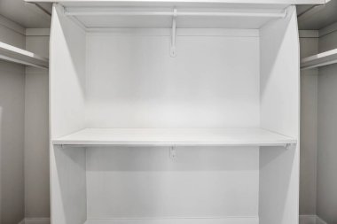 Rafı ve kıyafetleri olmayan beyaz bir dolap. Dolap boş ve raf boş.