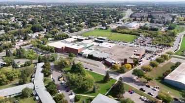 4K aerial view of Nutana Suburban Centre in Saskatoon, showing condos, retail, seniors housing, schools, and parks in this central east side neighborhood.