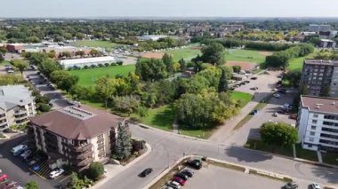 4K aerial view of Nutana Suburban Centre in Saskatoon, showing condos, retail, seniors housing, schools, and parks in this central east side neighborhood.
