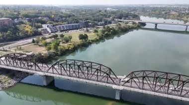 4K aerial view of Nutana in Saskatoon, looking over Rotary Park and the South Saskatchewan River with stunning city and riverside scenery.
