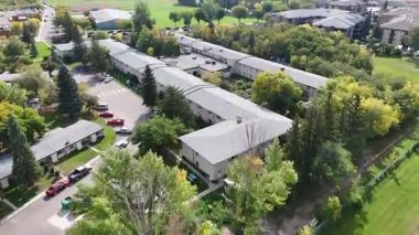 4K aerial view of Nutana Suburban Centre in Saskatoon, showing condos, retail, seniors housing, schools, and parks in this central east side neighborhood.