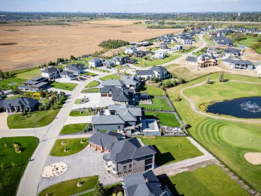 Saskatchewan, Saskatchewan yakınlarındaki Greenbryre hava manzarasında golf sahası yeşillikleri, lüks evler ve peyzaj alanları yer alıyor..