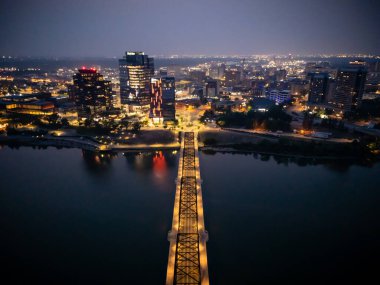 Saskatchewan, Saskatoon şehir merkezinin hava gece manzarası, şehrin ufuk çizgisi, köprüler ve aydınlık sokaklar.