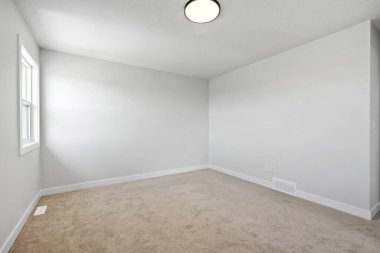 Penceresi ve lambası olan beyaz bir oda. Oda boş ve minimalist bir görünüşü var.