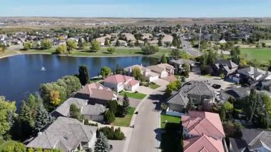 4K aerial view of Briarwood in Saskatoon during autumn, showcasing colorful trees, upscale homes, and parks in this established southeast neighborhood.