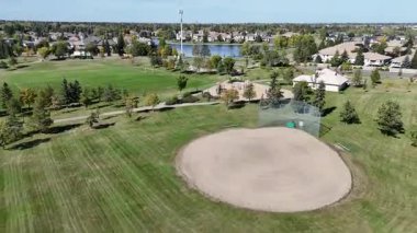4K aerial view of Briarwood in Saskatoon during autumn, showcasing colorful trees, upscale homes, and parks in this established southeast neighborhood.