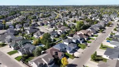 4K aerial view of Briarwood in Saskatoon during autumn, showcasing colorful trees, upscale homes, and parks in this established southeast neighborhood.