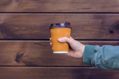 Kahve seviyorum! Kahve kahverengi ahşap arka plan önünde tutan kişinin el