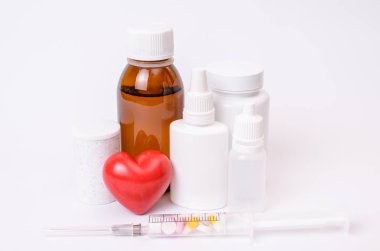 Tedavi ilaç hap tedavisi desen klinik kapak vidalı kapak kavramı. Birçok kutular dolu küçük kalp şırınga ile izole beyaz arka plan boşaltmak içinde renkli kapsül hap res fotoğrafı kapatın