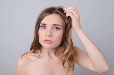 Kalıcı makyaj vitaminler mineraller hızlı kirli saç modeli konsept eksikliği. Üzgün üzgün sorunlu Bayan kırılgan sağlıksız esmer boyalı bukleler üzerinde el izole gri arka plan tutarak fotoğraf portre kadar kapatın
