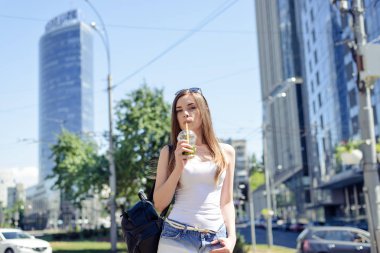 Plastik kap el rahat t-shirt denim kıyafeti giymiş elinde lezzetli tatlı soda içecek zevk oldukça memnun güzel çekici bir Bayan portresi fotoğraf