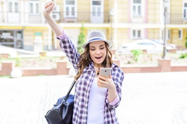 Facial emotion expressing chat connection roaming internet good news concept. Portrait of pretty beautiful glad cheerful rejoicing lady raising hands up looking at phone in hands receiving sending sms