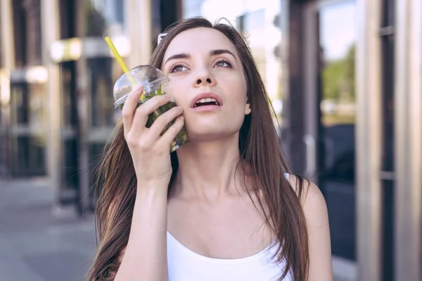 Emotion expressing people person concept. Close up photo portrait of exhausted tired thirsty woman touching attaching applying ice tea to the cheek waiting for rain drops